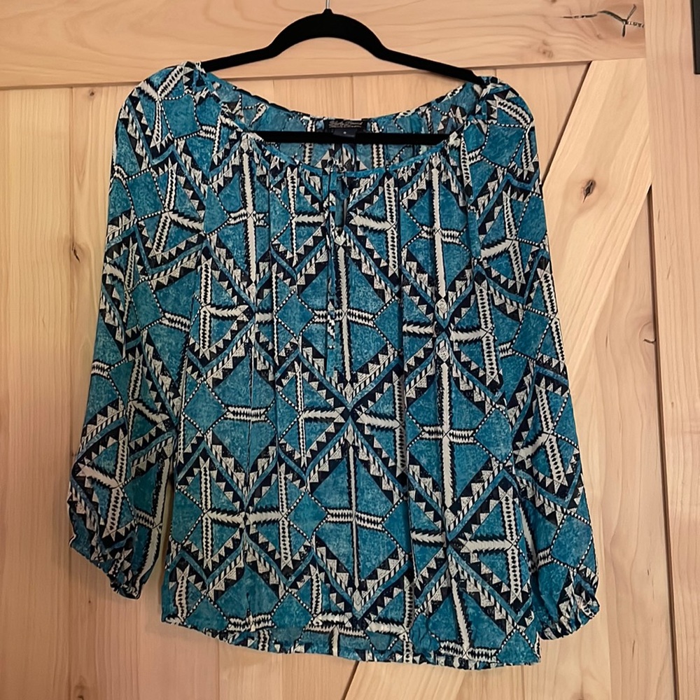 Lucky Brand woman’s top in blue/turquoise geometric pattern. Tie at neck.